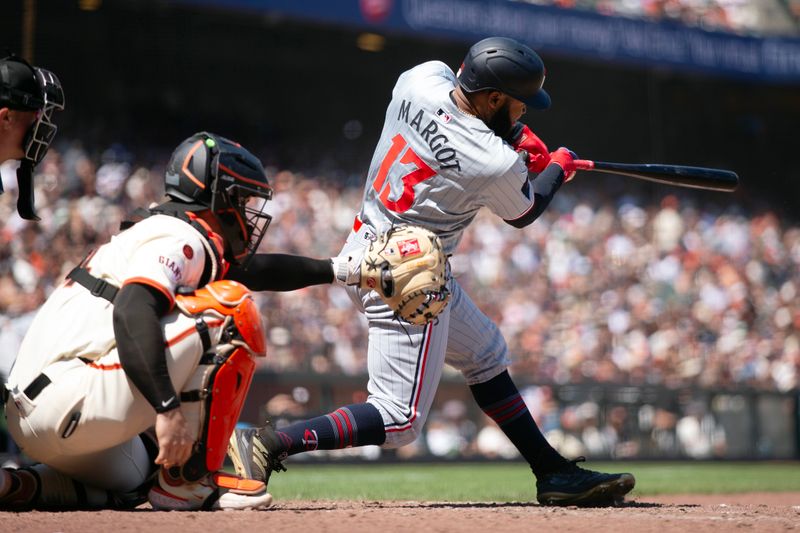Jul 14, 2024; San Francisco, California, USA; Minnesota Twins center fielder Manuel Margot (13) hits a two-RBI double against the San Francisco Giants during the ninth inning at Oracle Park. Mandatory Credit: D. Ross Cameron-USA TODAY Sports