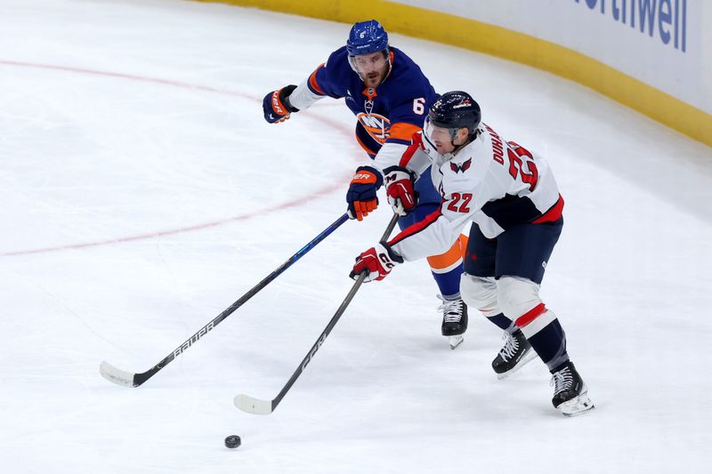 Oct 11, 2025; Elmont, New York, USA; Washington Capitals right wing Brandon Duhaime (22) plays the puck against New York Islanders defenseman Ryan Pulock (6) during the first period at UBS Arena. Mandatory Credit: Brad Penner-Imagn Images