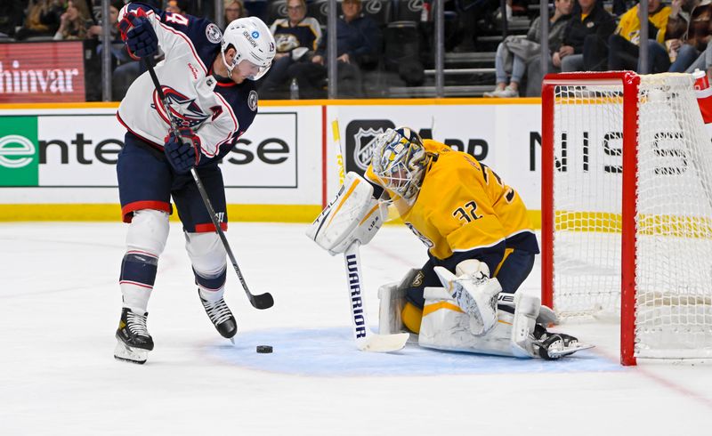 Jan 17, 2023; Nashville, Tennessee, USA;  Nashville Predators goaltender Kevin Lankinen (32) blocks the shot of Columbus Blue Jackets left wing Gustav Nyquist (14) during the second period at Bridgestone Arena. Mandatory Credit: Steve Roberts-USA TODAY Sports