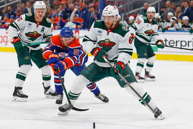 Dec 8, 2023; Edmonton, Alberta, CAN; Minnesota Wild defensemen Dakota Mermis (6) and Edmonton Oilers forward James Hamblin (57) chase after a loose puck during the first period at Rogers Place. Mandatory Credit: Perry Nelson-USA TODAY Sports