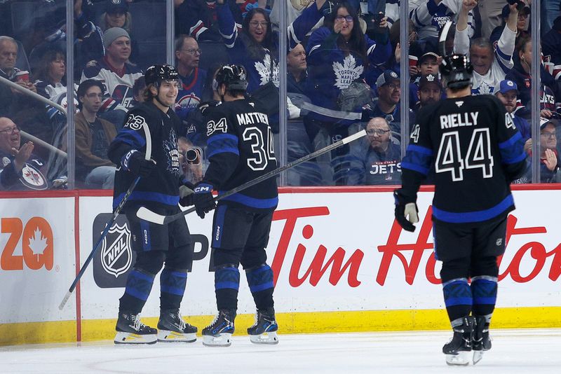 Oct 28, 2024; Winnipeg, Manitoba, CAN;  Toronto Maple Leafs forward Matthew Knies (23) is congratulated byToronto Maple Leafs forward Auston Matthews (34) on his goal against the Winnipeg Jets during the second period at Canada Life Centre. Mandatory Credit: Terrence Lee-Imagn Images