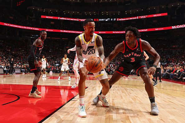 TORONTO, CANADA - DECEMBER 23:  John Collins #20 of the Utah Jazz handles the ball during the game as OG Anunoby #3 of the Toronto Raptors plays defense on December 23, 2023 at the Scotiabank Arena in Toronto, Ontario, Canada.  NOTE TO USER: User expressly acknowledges and agrees that, by downloading and or using this Photograph, user is consenting to the terms and conditions of the Getty Images License Agreement.  Mandatory Copyright Notice: Copyright 2023 NBAE (Photo by Vaughn Ridley/NBAE via Getty Images)