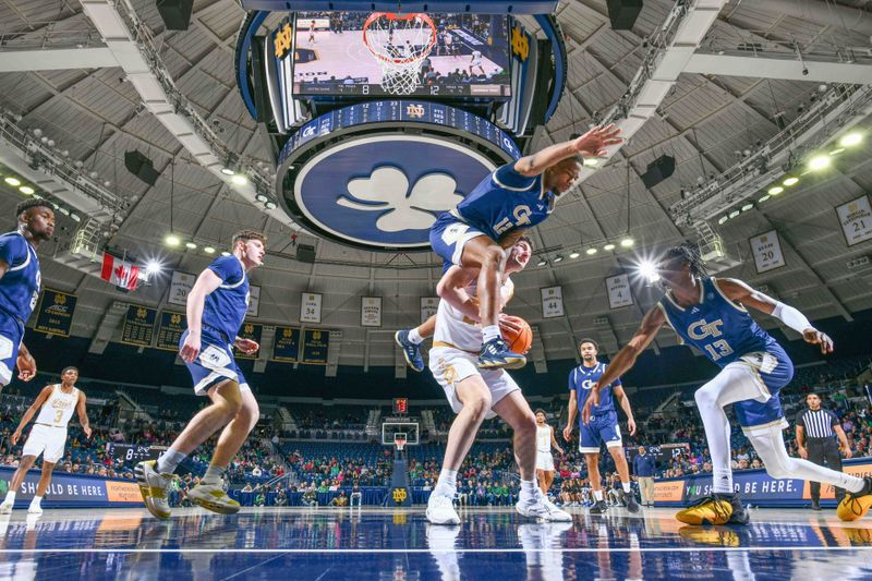 Feb 14, 2024; South Bend, Indiana, USA; Notre Dame Fighting Irish forward Matt Zona (25) is fouled by Georgia Tech Yellow Jackets forward Tyzhaun Claude (12) in the first half at the Purcell Pavilion. Mandatory Credit: Matt Cashore-USA TODAY Sports