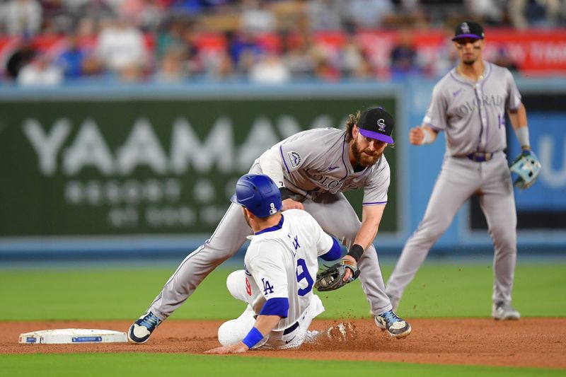 May 31, 2024; Los Angeles, California, USA; Colorado Rockies second baseman Brendan Rodgers (7) tags out Los Angeles Dodgers second baseman Gavin Lux (9) at second during the fifth inning at Dodger Stadium. Mandatory Credit: Gary A. Vasquez-USA TODAY Sports