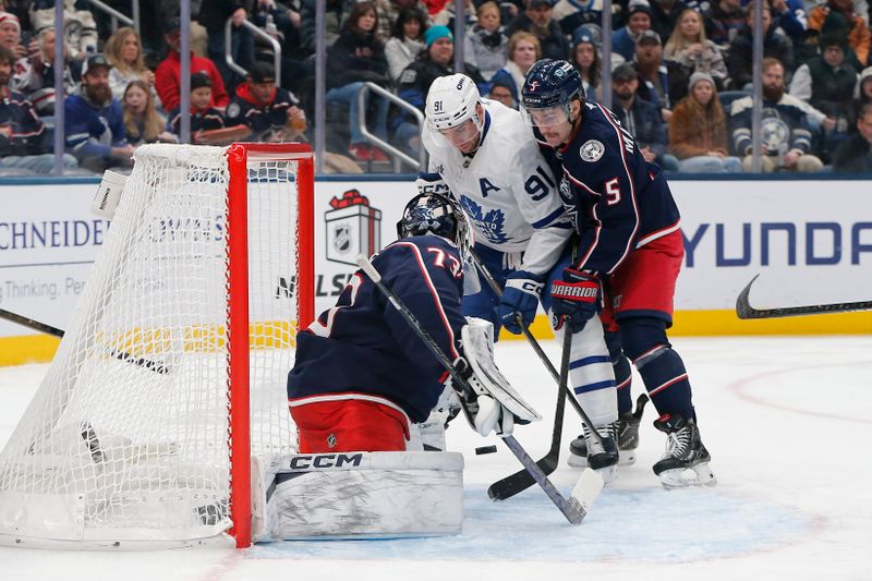 Nov 26, 2025; Columbus, Ohio, USA; Columbus Blue Jackets goalie Jet Greaves (73) makes a save as Toronto Maple Leafs center John Tavares (91) looks for a rebound during the first period at Nationwide Arena. Mandatory Credit: Russell LaBounty-Imagn Images