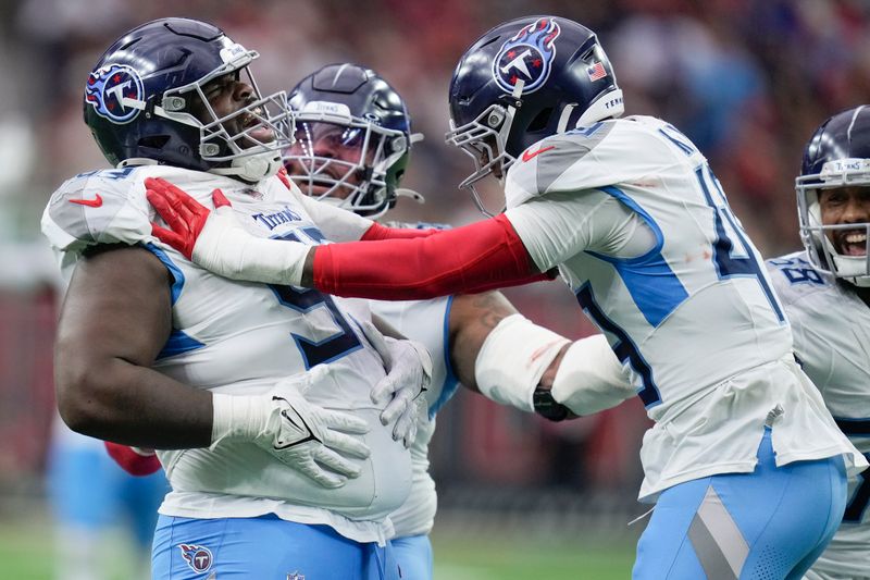 Tennessee Titans defensive tackle T'Vondre Sweat, left, celebrates a sack with linebacker Arden Key, right, during the second half an NFL football game against the Houston Texans, Sunday, Nov. 24, 2024, in Houston. (AP Photo/Eric Christian Smith)