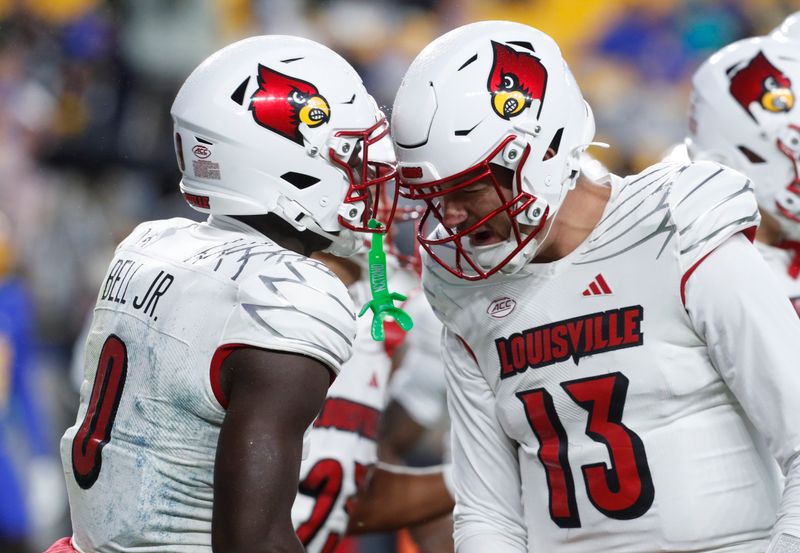 Oct 14, 2023; Pittsburgh, Pennsylvania, USA; Louisville Cardinals wide receiver Chris Bell (0) and quarterback Jack Plummer (13) react after combining for a seven yard touchdown pass against the Pittsburgh Panthers during the first quarter at Acrisure Stadium. Mandatory Credit: Charles LeClaire-USA TODAY Sports