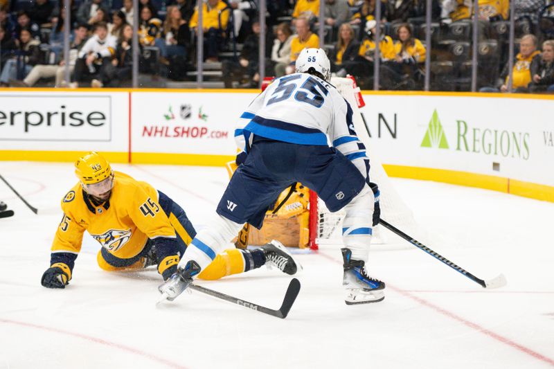 Nov 23, 2024; Nashville, Tennessee, USA;  Nashville Predators defenseman Alexandre Carrier (45) and goaltender Juuse Saros (74) blocks the shot of Winnipeg Jets center Mark Scheifele (55) during the second period at Bridgestone Arena. Mandatory Credit: Steve Roberts-Imagn Images