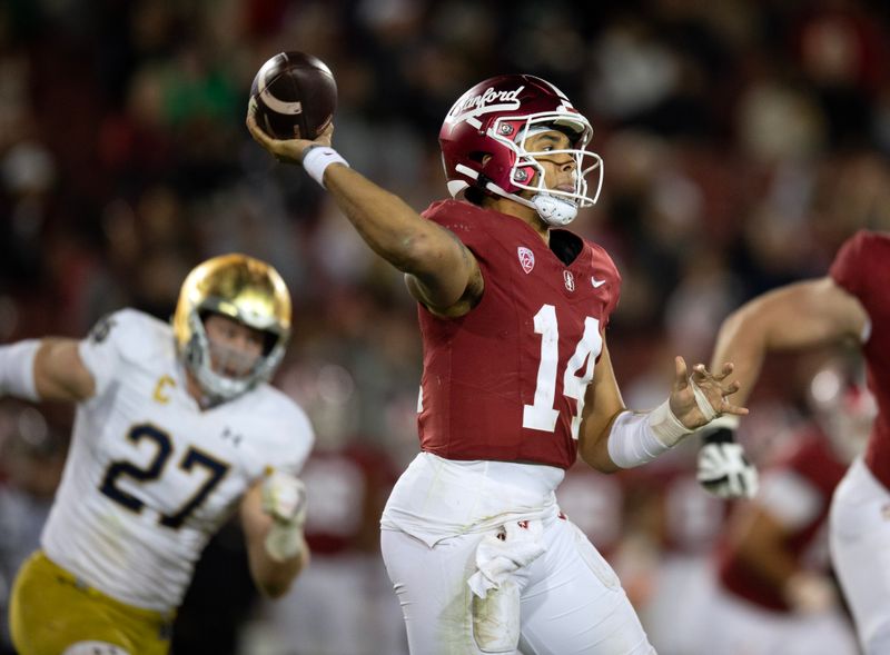 Nov 25, 2023; Stanford, California, USA; Stanford Cardinal quarterback Ashton Daniels (14) throws on the run while being pursued by Notre Dame Fighting Irish linebacker JD Bertrand (27) during the third quarter at Stanford Stadium. Mandatory Credit: D. Ross Cameron-USA TODAY Sports