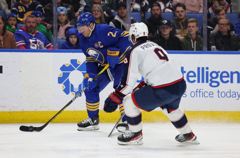 Dec 30, 2023; Buffalo, New York, USA;  Buffalo Sabres right wing Kyle Okposo (21) skates with the puck as Columbus Blue Jackets defenseman Ivan Provorov (9) defends during the second period at KeyBank Center. Mandatory Credit: Timothy T. Ludwig-USA TODAY Sports