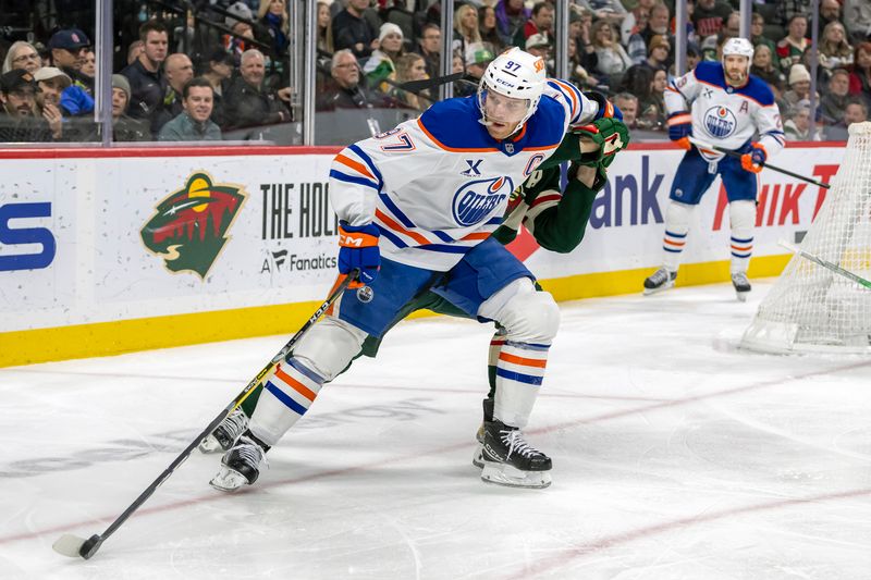 Jan 15, 2025; Saint Paul, Minnesota, USA;  Edmonton Oilers forward Connor McDavid (97) protects the puck from Minnesota Wild forward Joel Eriksson Ek (14) during the third period at Xcel Energy Center. Mandatory Credit: Nick Wosika-Imagn Images

