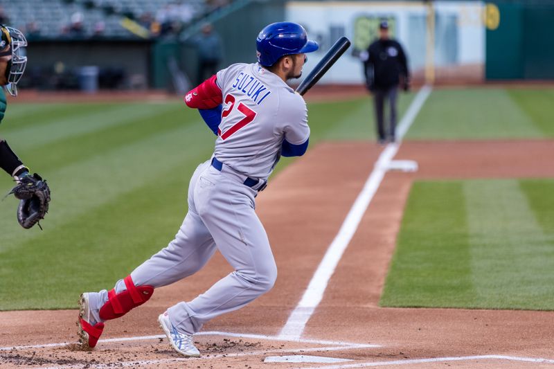 Apr 18, 2023; Oakland, California, USA;  Chicago Cubs right fielder Seiya Suzuki (27) hits a single against the Oakland Athletics during the first inning at RingCentral Coliseum. Mandatory Credit: John Hefti-USA TODAY Sports