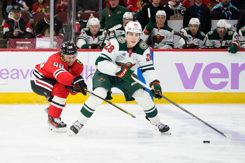 Jan 26, 2025; Chicago, Illinois, USA; Chicago Blackhawks center Connor Bedard (98) defends Minnesota Wild left wing Liam Ohgren (28) during the second period at United Center. Mandatory Credit: David Banks-Imagn Images