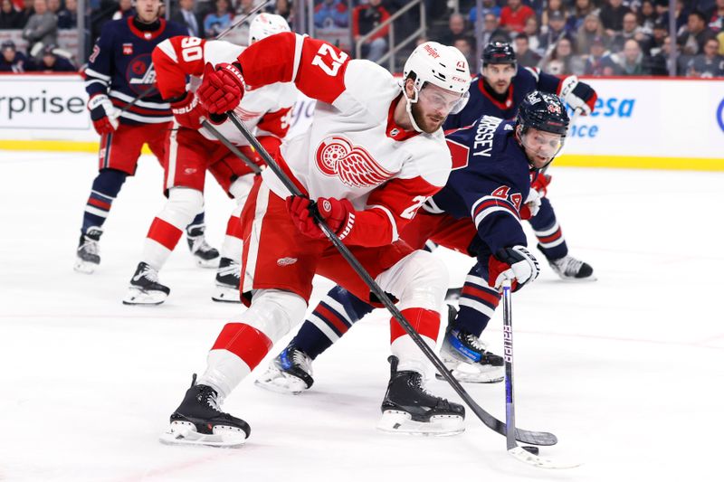 Dec 20, 2023; Winnipeg, Manitoba, CAN; Detroit Red Wings center Michael Rasmussen (27) is stick checked by Winnipeg Jets defenseman Josh Morrissey (44) in the first period at Canada Life Centre. Mandatory Credit: James Carey Lauder-USA TODAY Sports