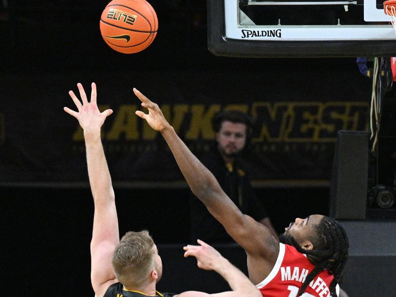 Feb 2, 2024; Iowa City, Iowa, USA; Ohio State Buckeyes guard Evan Mahaffey (12) defends the shot of Iowa Hawkeyes forward Ben Krikke (23) during the first half at Carver-Hawkeye Arena. Mandatory Credit: Jeffrey Becker-USA TODAY Sports