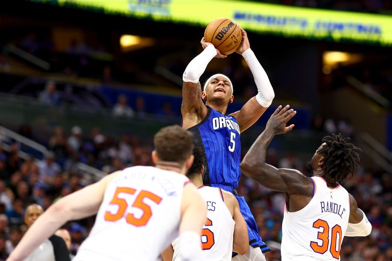 ORLANDO, FLORIDA - MARCH 23: Paolo Banchero #5 of the Orlando Magic looks to shoot against the New York Knicks defends during the third quarter at Amway Center on March 23, 2023 in Orlando, Florida. NOTE TO USER: User expressly acknowledges and agrees that, by downloading and or using this photograph, User is consenting to the terms and conditions of the Getty Images License Agreement. (Photo by Douglas P. DeFelice/Getty Images)