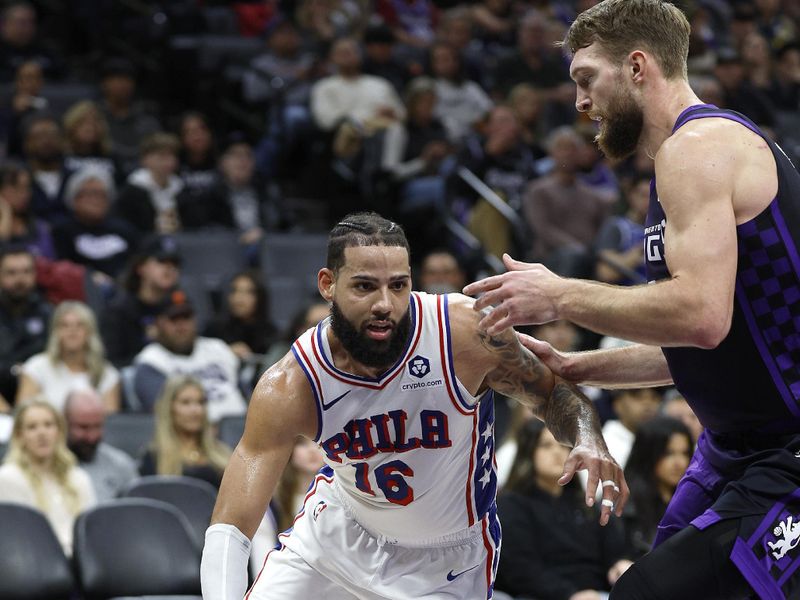 SACRAMENTO, CALIFORNIA - JANUARY 01: Caleb Martin #16 of the Philadelphia 76ers drives towards the basket on Domantas Sabonis #11 of the Sacramento Kings during the second half of an NBA basketball game at Golden 1 Center on January 01, 2025 in Sacramento, California. NOTE TO USER: User expressly acknowledges and agrees that, by downloading and or using this photograph, User is consenting to the terms and conditions of the Getty Images License Agreement. (Photo by Thearon W. Henderson/Getty Images)