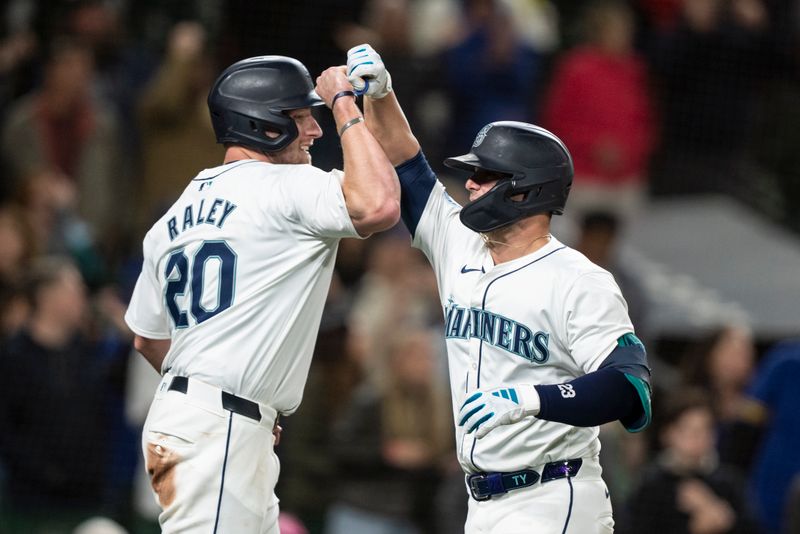 May 13, 2024; Seattle, Washington, USA; Seattle Mariners second baseman Ty France (23) is congratulated by left fielder Luke Raley (20) after hitting a two-run home run during the eighth inning against the Kansas City Royals at T-Mobile Park. Mandatory Credit: Stephen Brashear-USA TODAY Sports