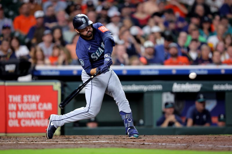 Sep 19, 2025; Houston, Texas, USA; Seattle Mariners third baseman Eugenio Suarez (28) hits a home run to left field against the Houston Astros during the fourth inning at Daikin Park. Mandatory Credit: Erik Williams-Imagn Images