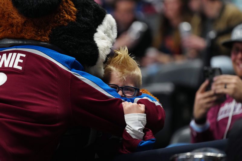 Apr 18, 2024; Denver, Colorado, USA; Colorado Avalanche mascot Berne hugs a young fan in the third period against the Edmonton Oilers at Ball Arena. Mandatory Credit: Ron Chenoy-USA TODAY Sports