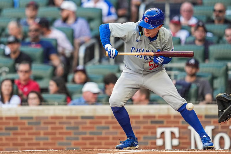 May 15, 2024; Cumberland, Georgia, USA; Chicago Cubs center fielder Pete Crow-Armstrong (52) is hit by a pitch while trying to bunt against the Atlanta Braves during the first inning at Truist Park. Mandatory Credit: Dale Zanine-USA TODAY Sports