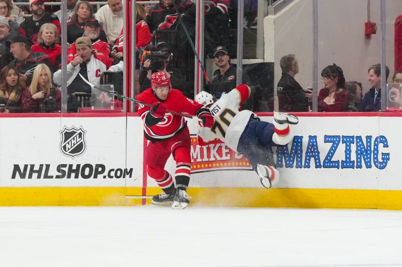 Jan 16, 2026; Raleigh, North Carolina, USA;  Carolina Hurricanes defenseman Sean Walker (26) checks Florida Panthers center Jesper Boqvist (70) during the second period at Lenovo Center. Mandatory Credit: James Guillory-Imagn Images