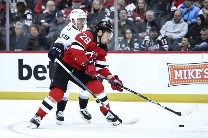 Feb 12, 2024; Newark, New Jersey, USA; New Jersey Devils right wing Timo Meier (28) skates with the puck against Seattle Kraken defenseman Ryker Evans (39) during the second period at Prudential Center. Mandatory Credit: John Jones-USA TODAY Sports