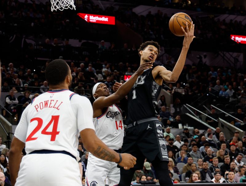 SAN ANTONIO, TX - JANUARY 29: Victor Wembanyama #1 of the San Antonio Spurs grabs a rebound over Terance Mann #14 of the Los Angeles Clippers in the first half at Frost Bank Center on January 29, 2025 in San Antonio, Texas. NOTE TO USER: User expressly acknowledges and agrees that, by downloading and or using this photograph, User is consenting to terms and conditions of the Getty Images License Agreement. (Photo by Ronald Cortes/Getty Images)