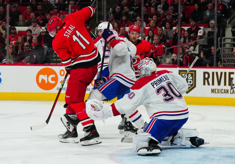 Dec 28, 2023; Raleigh, North Carolina, USA; Carolina Hurricanes center Jordan Staal (11) goes for the tip against Montreal Canadiens goaltender Cayden Primeau (30) during the third period at PNC Arena. Mandatory Credit: James Guillory-USA TODAY Sports