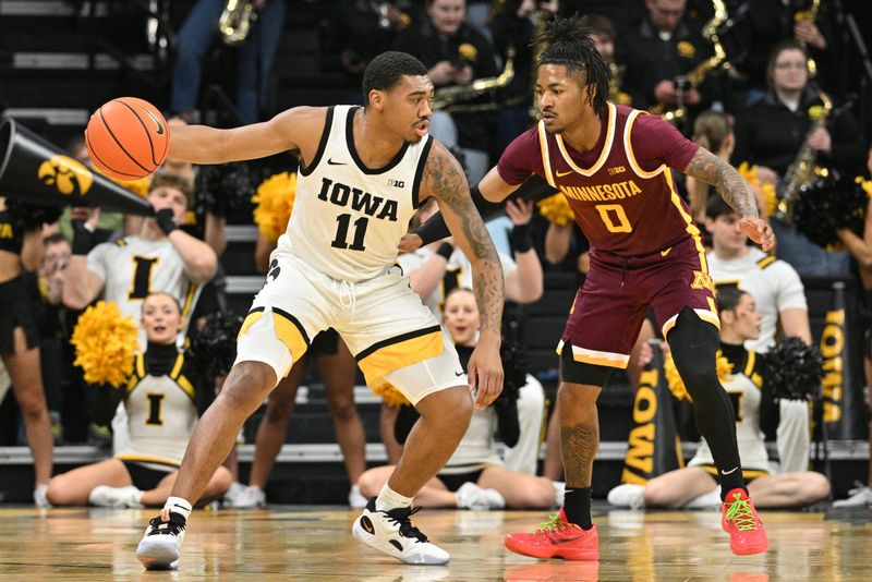 Feb 11, 2024; Iowa City, Iowa, USA; Iowa Hawkeyes guard Tony Perkins (11) is defended by Minnesota Golden Gophers guard Elijah Hawkins (0) during the first half at Carver-Hawkeye Arena. Mandatory Credit: Jeffrey Becker-USA TODAY Sports