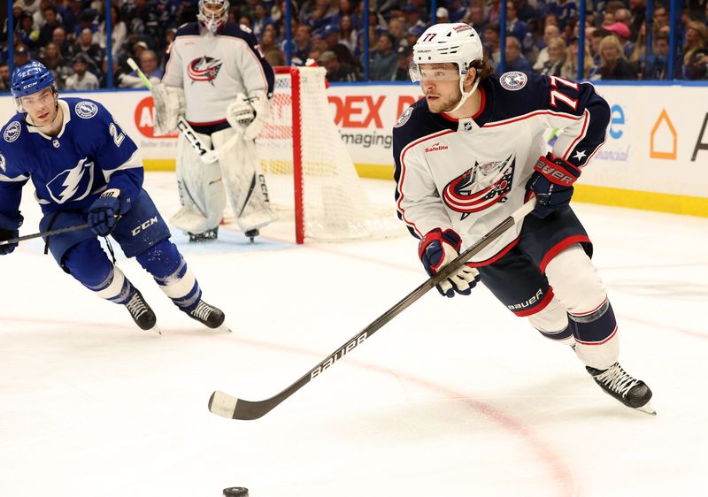 Apr 9, 2024; Tampa, Florida, USA; Columbus Blue Jackets defenseman Nick Blankenburg (77) skates with the puck as Tampa Bay Lightning center Brayden Point (21) defends during the third period at Amalie Arena. Mandatory Credit: Kim Klement Neitzel-USA TODAY Sports