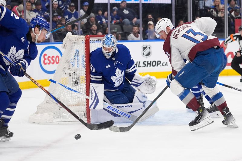 Jan 25, 2026; Toronto, Ontario, CAN; Colorado Avalanche forward Valeri Nichushkin (13) and Toronto Maple Leafs defenseman Simon Benoit (2) go after a rebound as Toronto Maple Leafs goaltender Joseph Woll (60) looks on during the second period at Scotiabank Arena. Mandatory Credit: John E. Sokolowski-Imagn Images