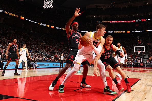 TORONTO, CANADA - DECEMBER 23:  Walker Kessler #24 of the Utah Jazz handles the ball during the game as Malachi Flynn #22 of the Toronto Raptors plays defense on December 23, 2023 at the Scotiabank Arena in Toronto, Ontario, Canada.  NOTE TO USER: User expressly acknowledges and agrees that, by downloading and or using this Photograph, user is consenting to the terms and conditions of the Getty Images License Agreement.  Mandatory Copyright Notice: Copyright 2023 NBAE (Photo by Vaughn Ridley/NBAE via Getty Images)