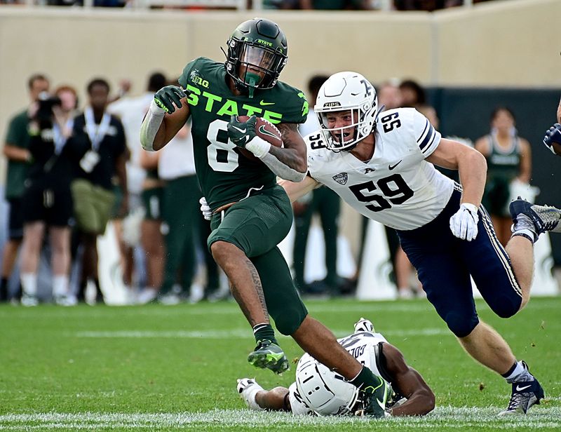 Sep 10, 2022; East Lansing, Michigan, USA;   Michigan State Spartans running back Jalen Berger (8) runs upfield past Akron Zips linebacker Andrew Behm (59) in the third quarter. Mandatory Credit: Dale Young-USA TODAY Sports