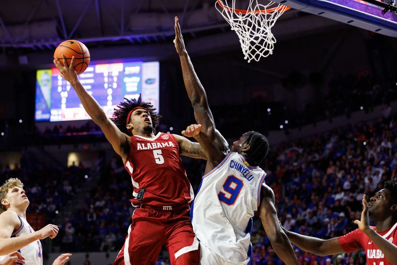 Feb 1, 2026; Gainesville, Florida, USA; Alabama Crimson Tide forward Amari Allen (5) makes a layup over Florida Gators center Rueben Chinyelu (9) during the first half at Exactech Arena at the Stephen C. O'Connell Center. Mandatory Credit: Matt Pendleton-Imagn Images