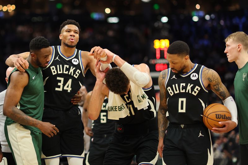 MILWAUKEE, WISCONSIN - APRIL 09: Giannis Antetokounmpo #34 of the Milwaukee Bucks is helped off the court by Thanasis Antetokounmpo #43 and Brook Lopez #11 after suffering an injury during the second half of a game against the Boston Celtics at Fiserv Forum on April 09, 2024 in Milwaukee, Wisconsin. NOTE TO USER: User expressly acknowledges and agrees that, by downloading and or using this photograph, User is consenting to the terms and conditions of the Getty Images License Agreement. (Photo by Stacy Revere/Getty Images)