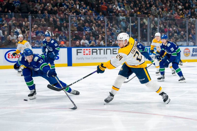 Jan 3, 2025; Vancouver, British Columbia, CAN; Nashville Predators defenseman Spencer Stastney (24) shoots against Vancouver Canucks defenseman Tyler Myers (57) in the first period at Rogers Arena. Mandatory Credit: Bob Frid-Imagn Images