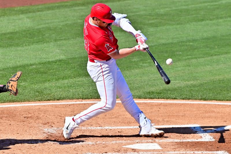 Feb 29, 2024; Tempe, Arizona, USA;  Los Angeles Angels second baseman Brandon Drury (23) hits an RBI single in the fourth inning against the Cleveland Guardians during a spring training game at Tempe Diablo Stadium. Mandatory Credit: Matt Kartozian-USA TODAY Sports