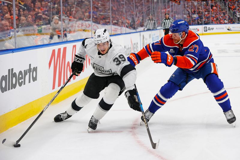 May 1, 2025; Edmonton, Alberta, CAN; Los Angeles Kings forward Jeff Malott (39) protects the puck from Edmonton Oilers defensemen Brett Kulak (27)  during the second period in game six of the first round of the 2025 Stanley Cup Playoffs at Rogers Place. Mandatory Credit: Perry Nelson-Imagn Images