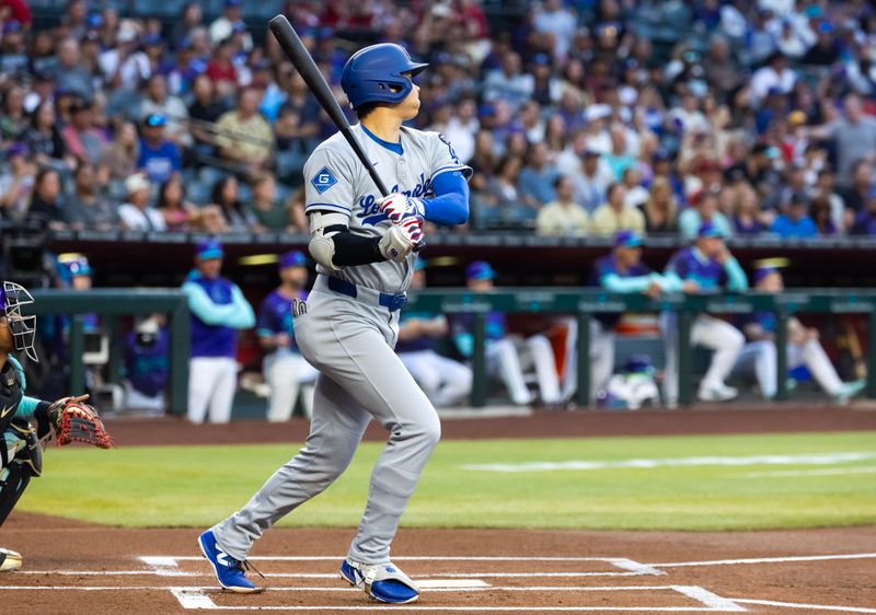 May 9, 2025; Phoenix, Arizona, USA; Arizona Diamondbacks designated hitter Shohei Ohtani hits a double in the first inning against the Los Angeles Dodgers at Chase Field. Mandatory Credit: Mark J. Rebilas-Imagn Images