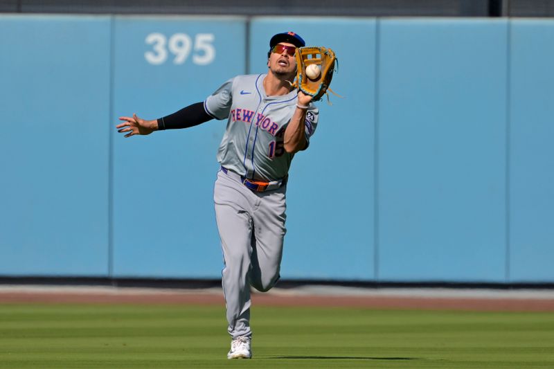 Oct 14, 2024; Los Angeles, California, USA; New York Mets outfielder Tyrone Taylor (15) makes a catch against Los Angeles Dodgers shortstop Mookie Betts (50) in the third inning during game two of the NLCS for the 2024 MLB Playoffs at Dodger Stadium. Mandatory Credit: Jayne Kamin-Oncea-Imagn Images