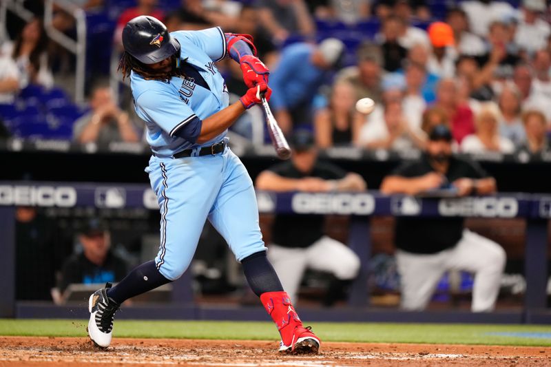 Jun 20, 2023; Miami, Florida, USA; Toronto Blue Jays first baseman Vladimir Guerrero Jr. (27) hits a double against the Miami Marlins during the seventh inning at loanDepot Park. Mandatory Credit: Rich Storry-USA TODAY Sports