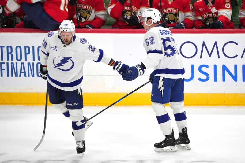 Sep 30, 2024; Sunrise, Florida, USA; Tampa Bay Lightning center Zemgus Girgensons (28) congratulates right wing Maxim Groshev (52) on his empty net goal during the third period against the Florida Panthers at Amerant Bank Arena. Mandatory Credit: Jim Rassol-Imagn Images