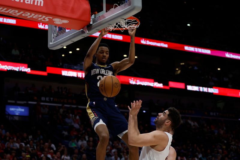 NEW ORLEANS, LOUISIANA - MARCH 13: Trey Murphy III #25 of the New Orleans Pelicans dunks the ball over Georges Niang #20 of the Cleveland Cavaliers at Smoothie King Center on March 13, 2024 in New Orleans, Louisiana.   NOTE TO USER: User expressly acknowledges and agrees that, by downloading and or using this photograph, User is consenting to the terms and conditions of the Getty Images License Agreement.  (Photo by Chris Graythen/Getty Images)