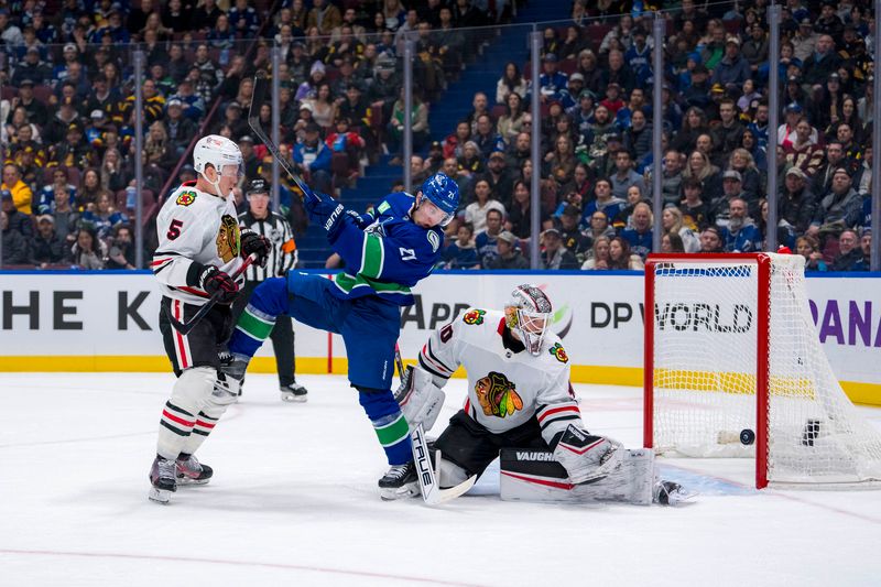 Nov 16, 2024; Vancouver, British Columbia, CAN; Chicago Blackhawks defenseman Connor Murphy (5) and Vancouver Canucks forward Nils Hoglander (21) battle for the rebound in front of Chicago goalie Arvid Soderblom (40) during the first period at Rogers Arena. Mandatory Credit: Bob Frid-Imagn Images