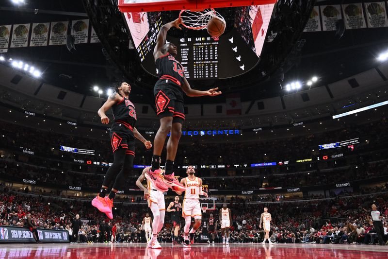 CHICAGO, ILLINOIS - APRIL 17:  Ayo Dosunmu #12 of the Chicago Bulls finishes off a fast break with a dunk in the second half against the Atlanta Hawks during a play-in tournament game at United Center on April 17, 2024 in Chicago, Illinois. Chicago defeated Atlanta 131-116. NOTE TO USER: User expressly acknowledges and agrees that, by downloading and or using this photograph, User is consenting to the terms and conditions of the Getty Images License Agreement.  (Photo by Jamie Sabau/Getty Images)