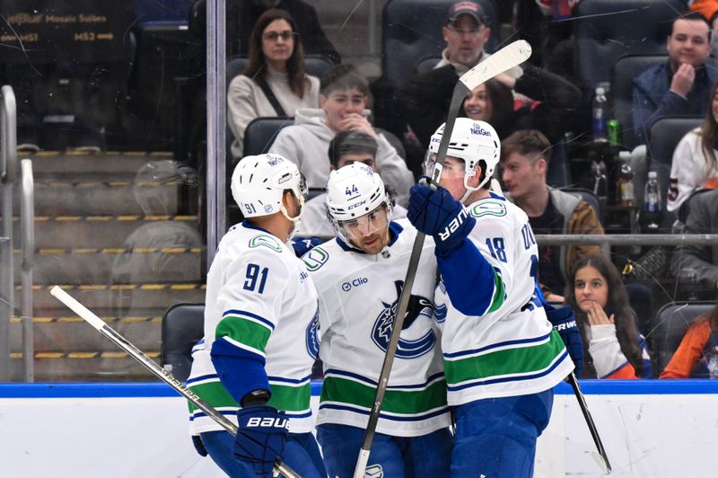 Dec 19, 2025; Elmont, New York, USA; Vancouver Canucks left wing Kiefer Sherwood (44) celebrates with teammates after scoring a goal against the New York Islanders during the first period at UBS Arena. Mandatory Credit: John Jones-Imagn Images