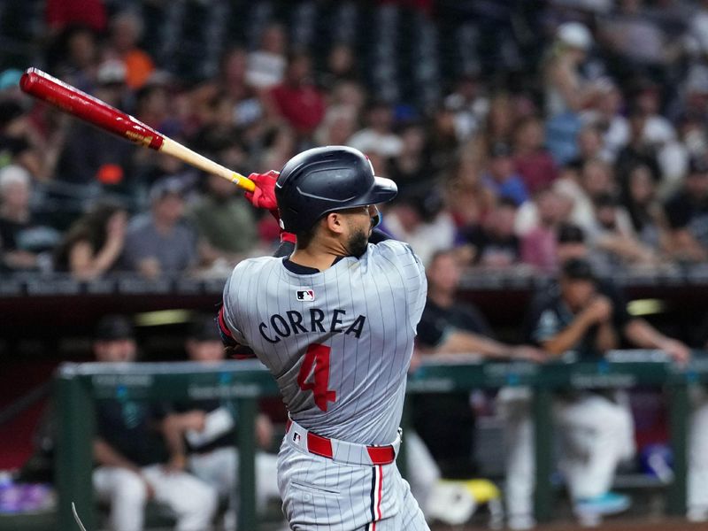 Jun 26, 2024; Phoenix, Arizona, USA; Minnesota Twins shortstop Carlos Correa (4) hits a single against the Arizona Diamondbacks during the third inning at Chase Field. Mandatory Credit: Joe Camporeale-USA TODAY Sports