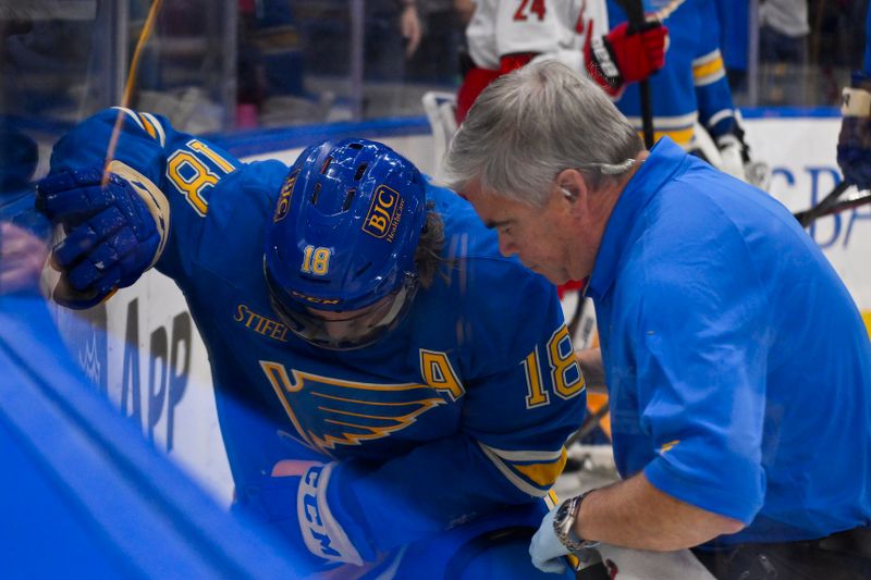 Oct 19, 2024; St. Louis, Missouri, USA;  St. Louis Blues center Robert Thomas (18) is checked on by a trainer during the third period against the Carolina Hurricanes at Enterprise Center. Mandatory Credit: Jeff Curry-Imagn Images