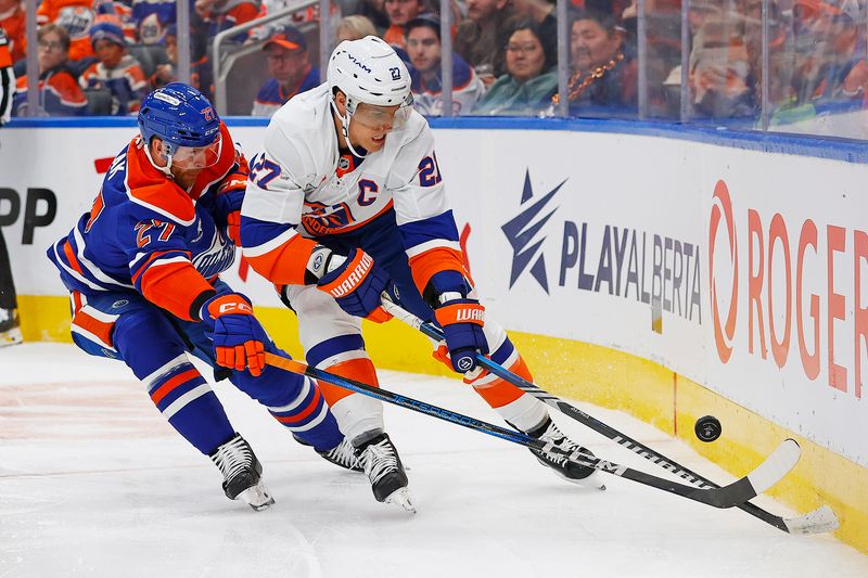 Nov 12, 2024; Edmonton, Alberta, CAN; New York Islanders forward Anders Lee (27) and Edmonton Oilers defensemen Brett Kulak (27)  battle along the boards for a loose puck  during the second period at Rogers Place. Mandatory Credit: Perry Nelson-Imagn Images